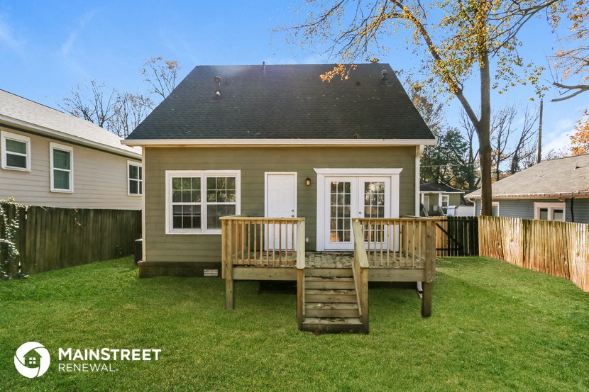 the backyard of a small house with a deck and a porch