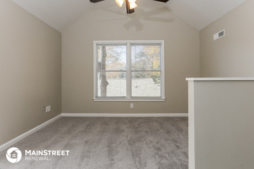 the master bedroom has a large window and carpeted flooring