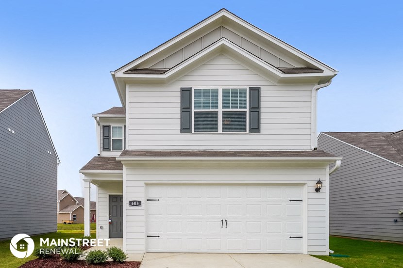 the exterior of a white house with a garage door