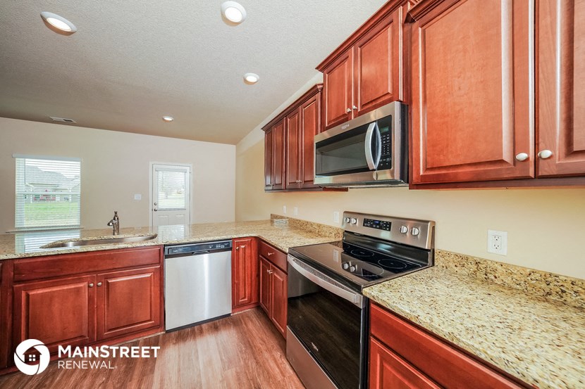 a kitchen with wooden cabinets and stainless steel appliances and granite counter tops