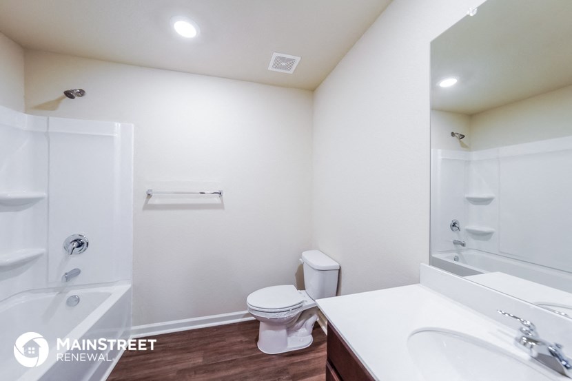 a bathroom with a toilet sink and shower and a mirror