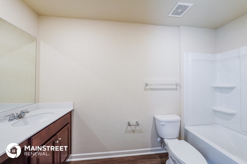 a bathroom with a toilet sink and tub and a mirror