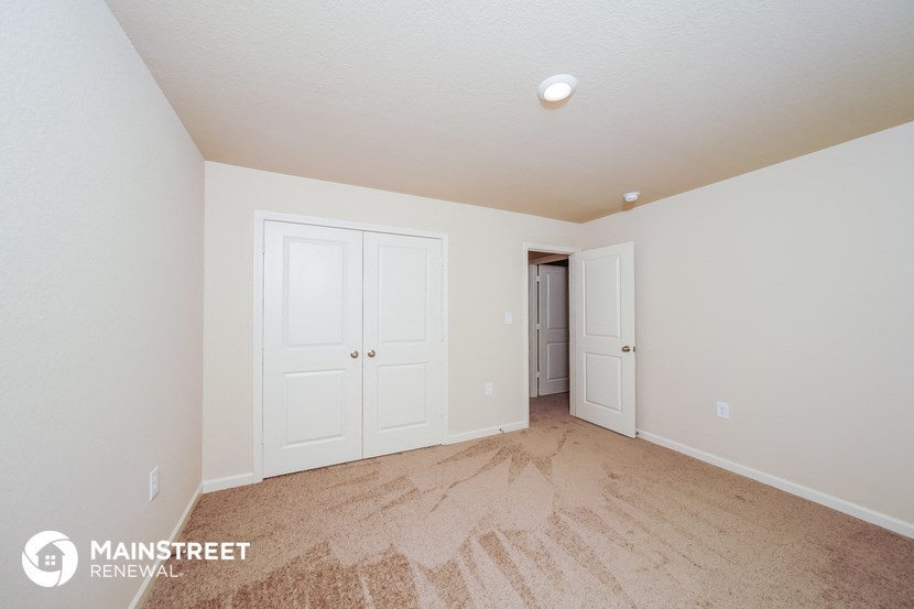 a master bedroom with two closets and a carpeted floor