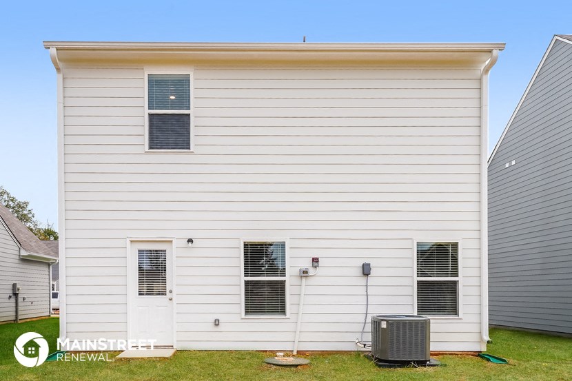 a side view of a white house with a air conditioner
