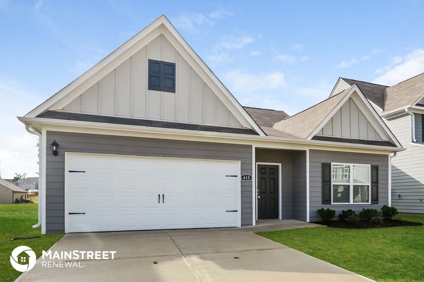 a home with a white garage door and a lawn