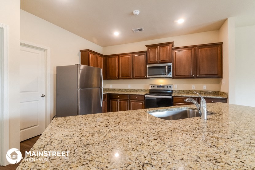 the kitchen has granite counter tops and stainless steel appliances