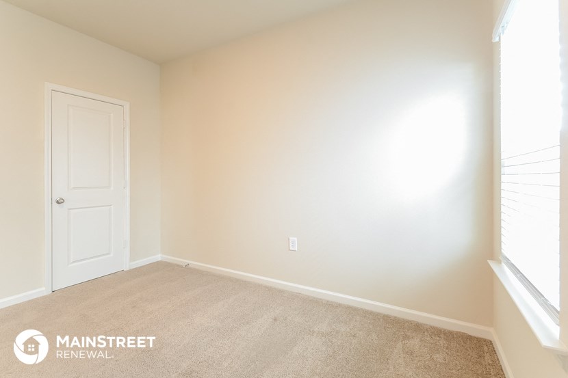 a bedroom with a white door and a carpeted floor