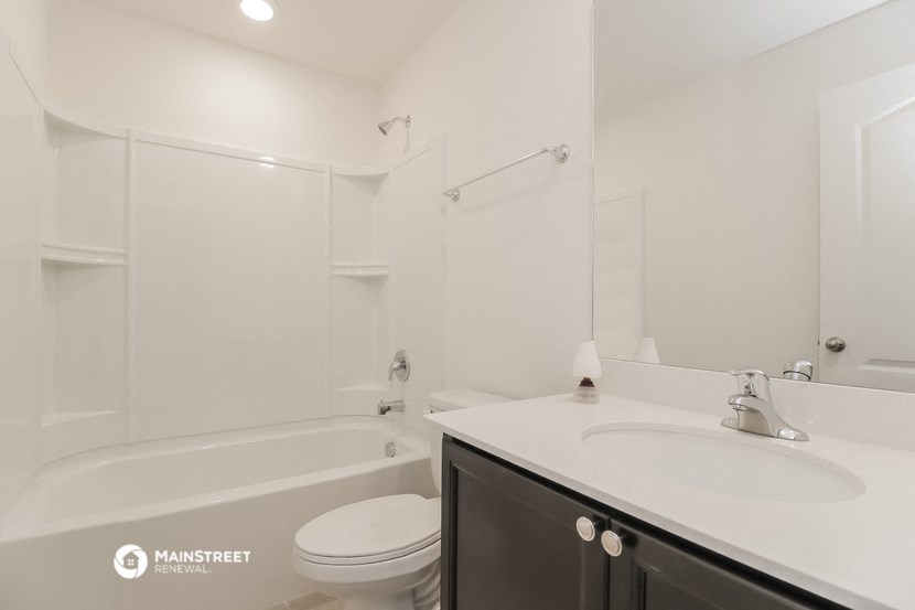 a white bathroom with a sink toilet and shower