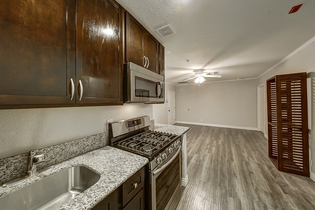 an empty kitchen with wood cabinets and stainless steel appliances