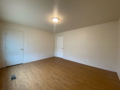 a living room with a wood floor and white walls