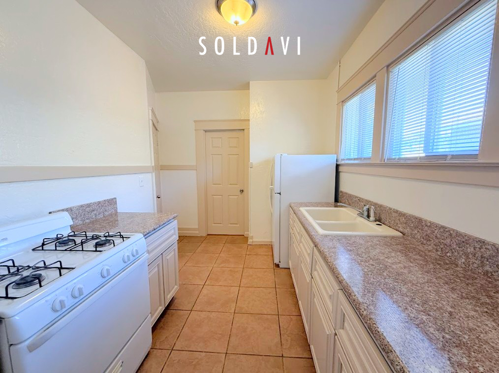 A kitchen with a gas stove, sink, and cabinets is marked as sold.