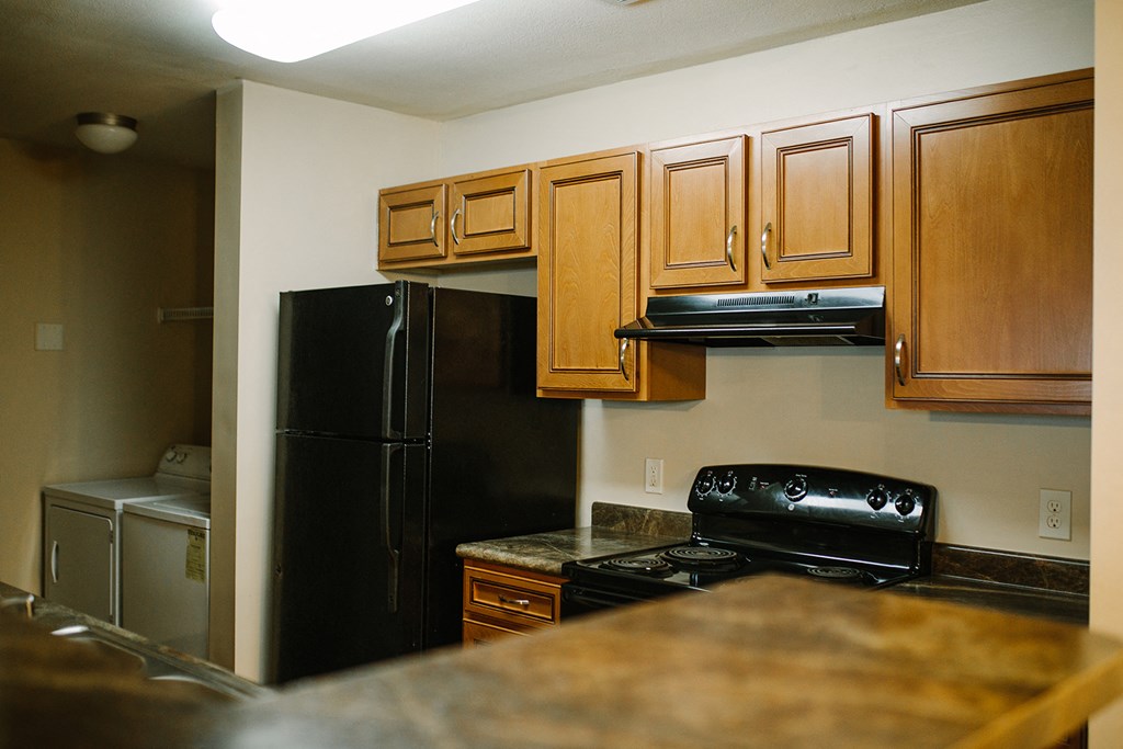 a kitchen with black appliances and wood cabinets