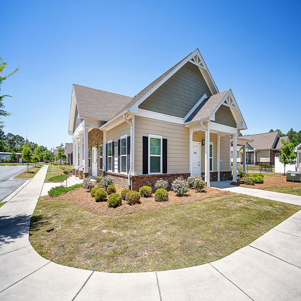 a house with a lawn and a sidewalk in front of it