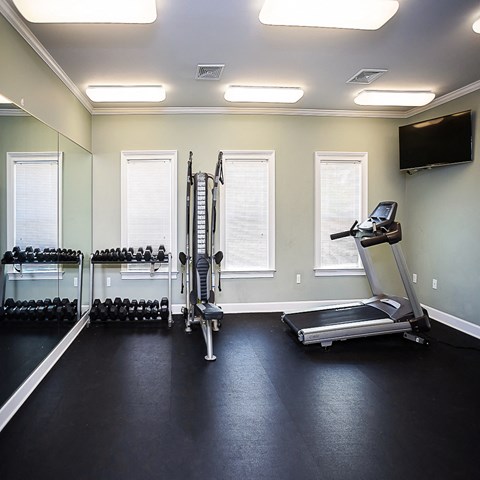 a home gym with exercise equipment and a tv