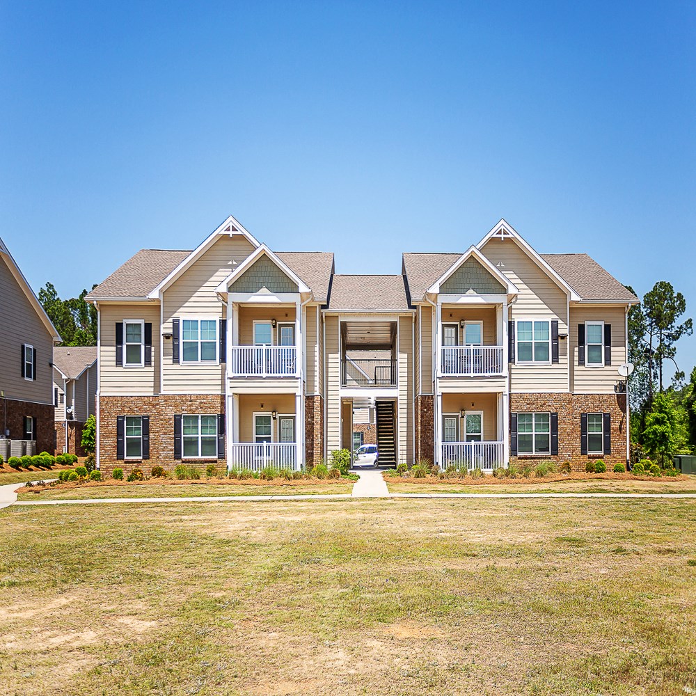 an apartment building with a yard in front of it