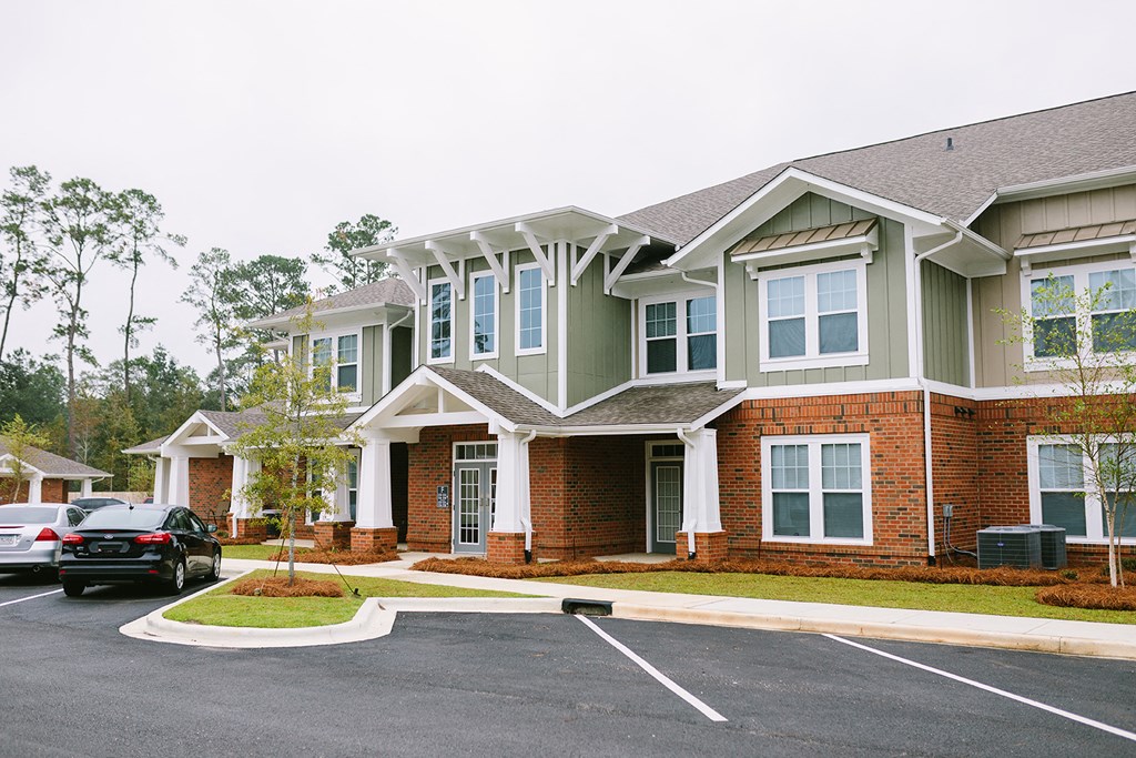 a large brick house with cars parked in a parking lot