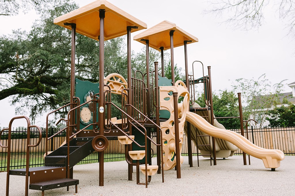 a playground with a swing set and slides in a park