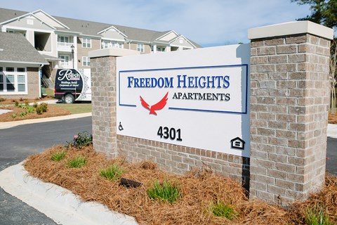 a sign for freedom heights apartments in front of a building