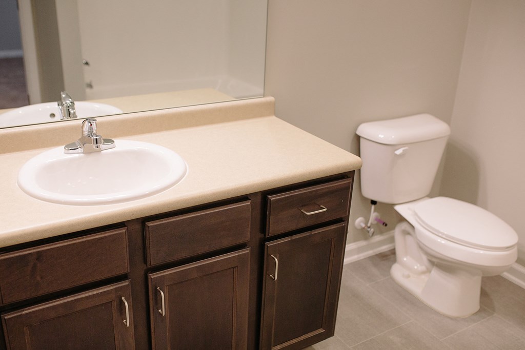 an empty bathroom with a sink toilet and mirror
