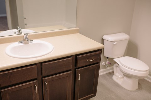 an empty bathroom with a sink toilet and mirror