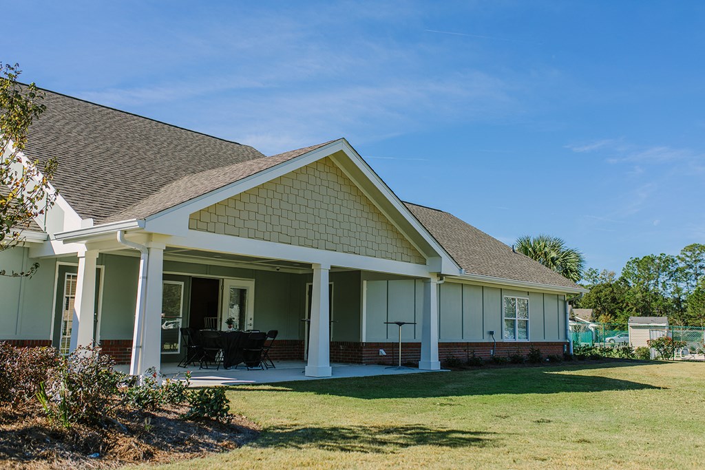 the front of a house with a porch and a lawn