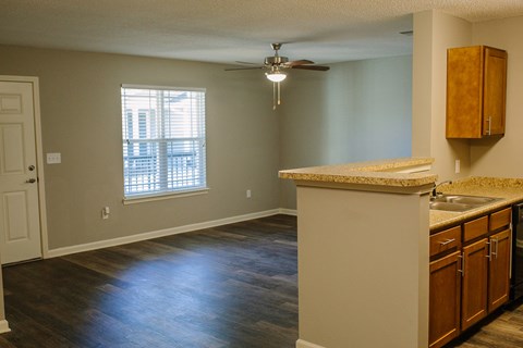 an empty kitchen and living room with a ceiling fan
