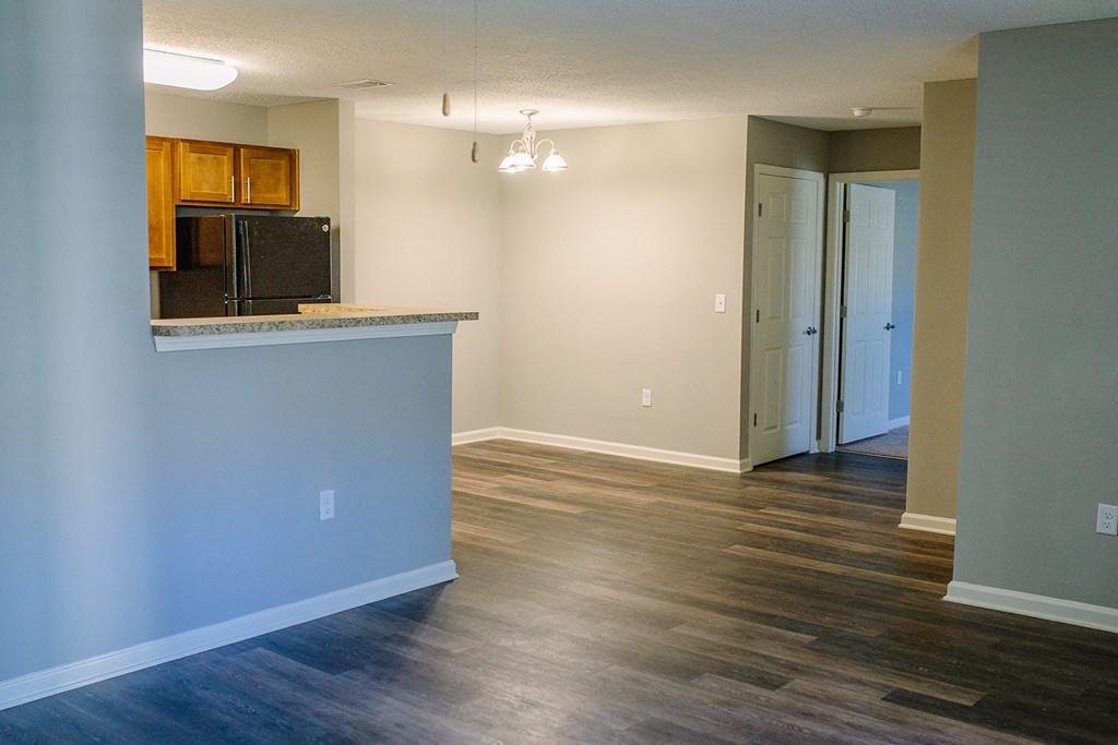 an empty kitchen and living room with a hard wood floor