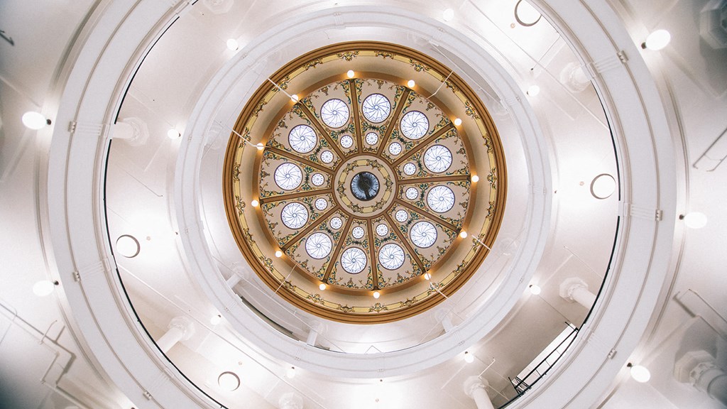 the ceiling of a building with a large stained glass window