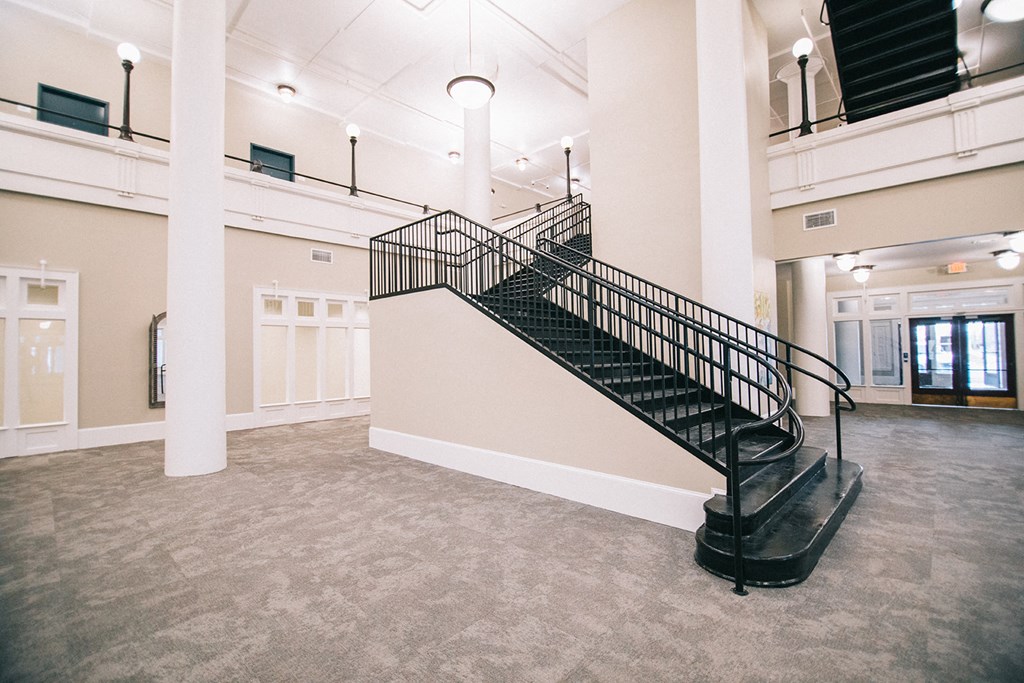 the lobby of a building with a staircase in the center