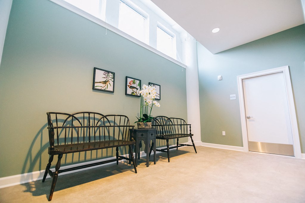 a dining room with two benches and a table with flowers