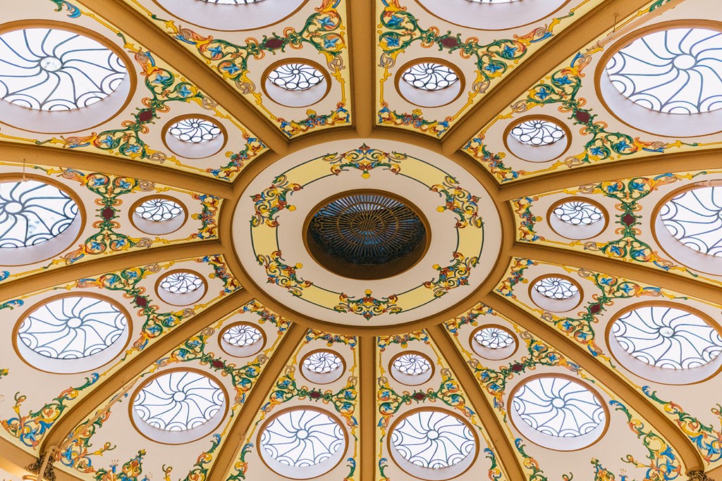 the ornate ceiling of a church with blue and yellow stained glass