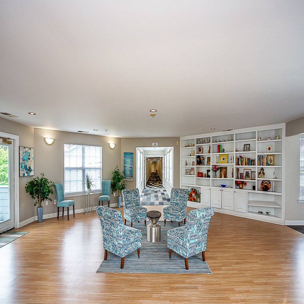 a living room with a table and chairs and a book shelf