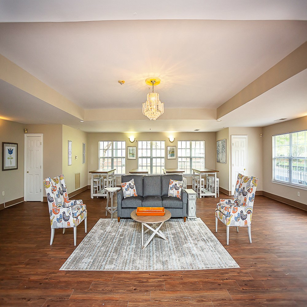 a living room with a couch and chairs and a dining room table
