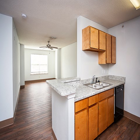 an empty kitchen with wood flooring and a counter top