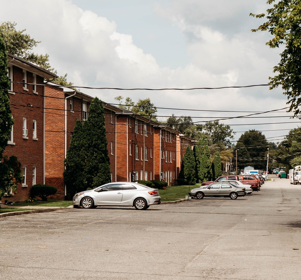 a street with cars parked in front of a brick building