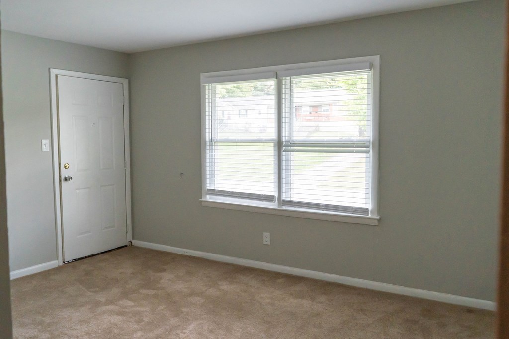 an empty room with a window and a door