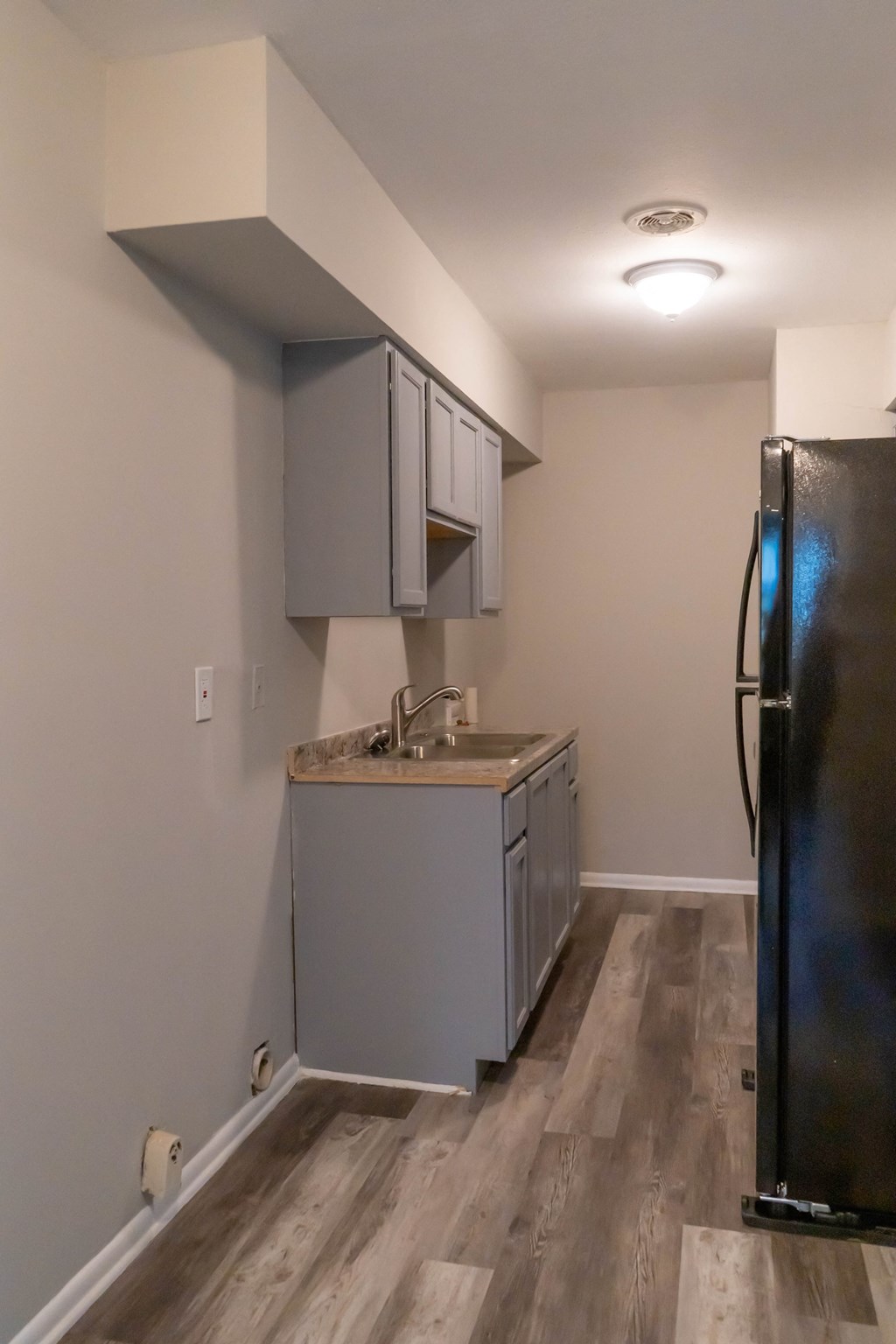 a small kitchen with a sink and a refrigerator