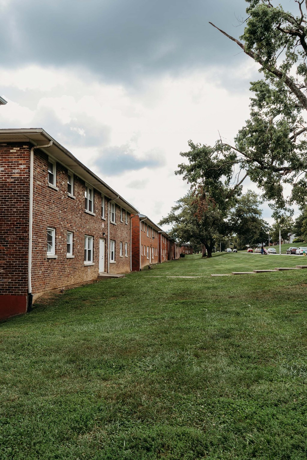a row of brick apartment buildings on a grass field