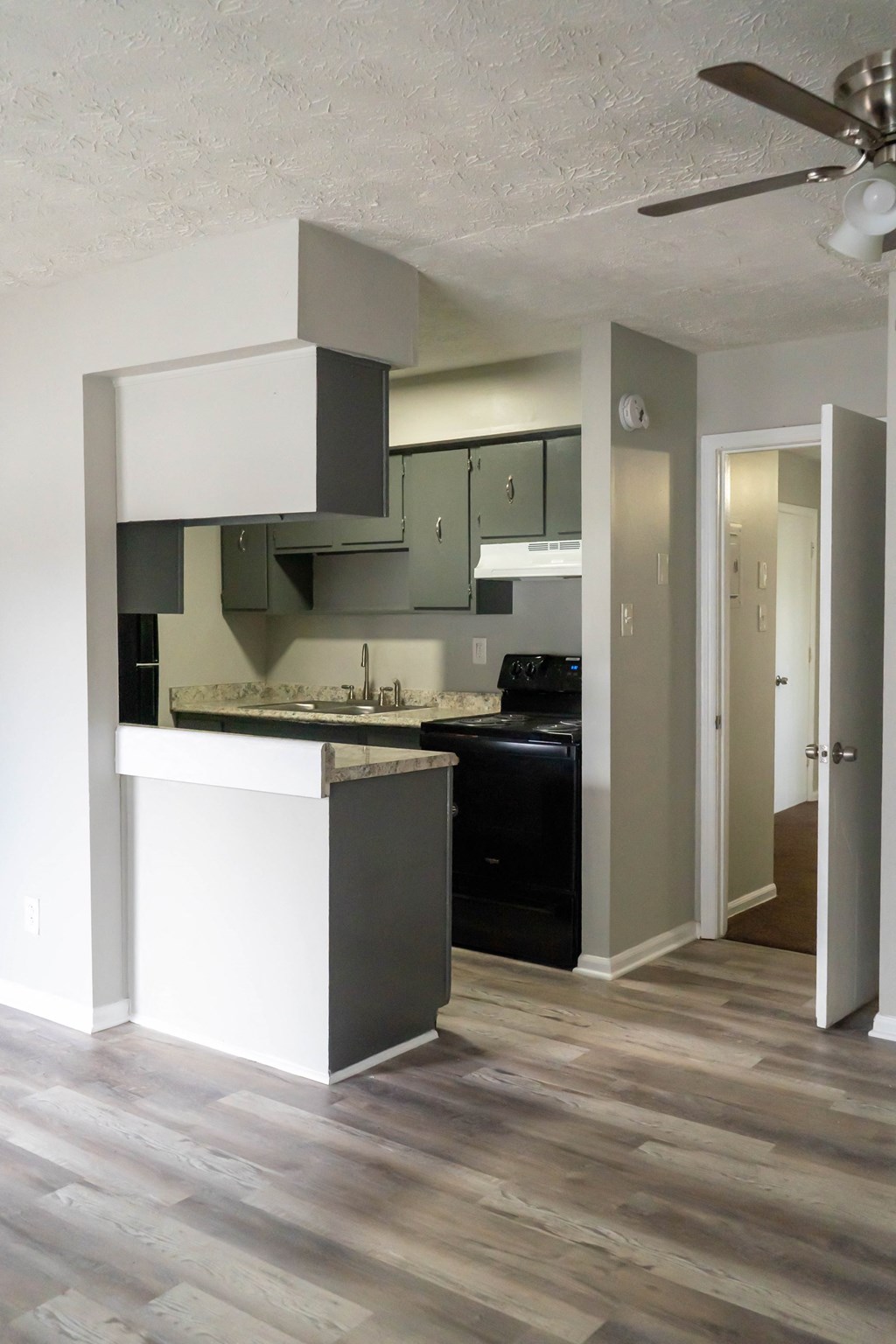 an empty kitchen with black appliances and white cabinets