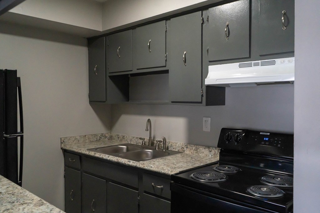 a kitchen with granite counter tops and black appliances