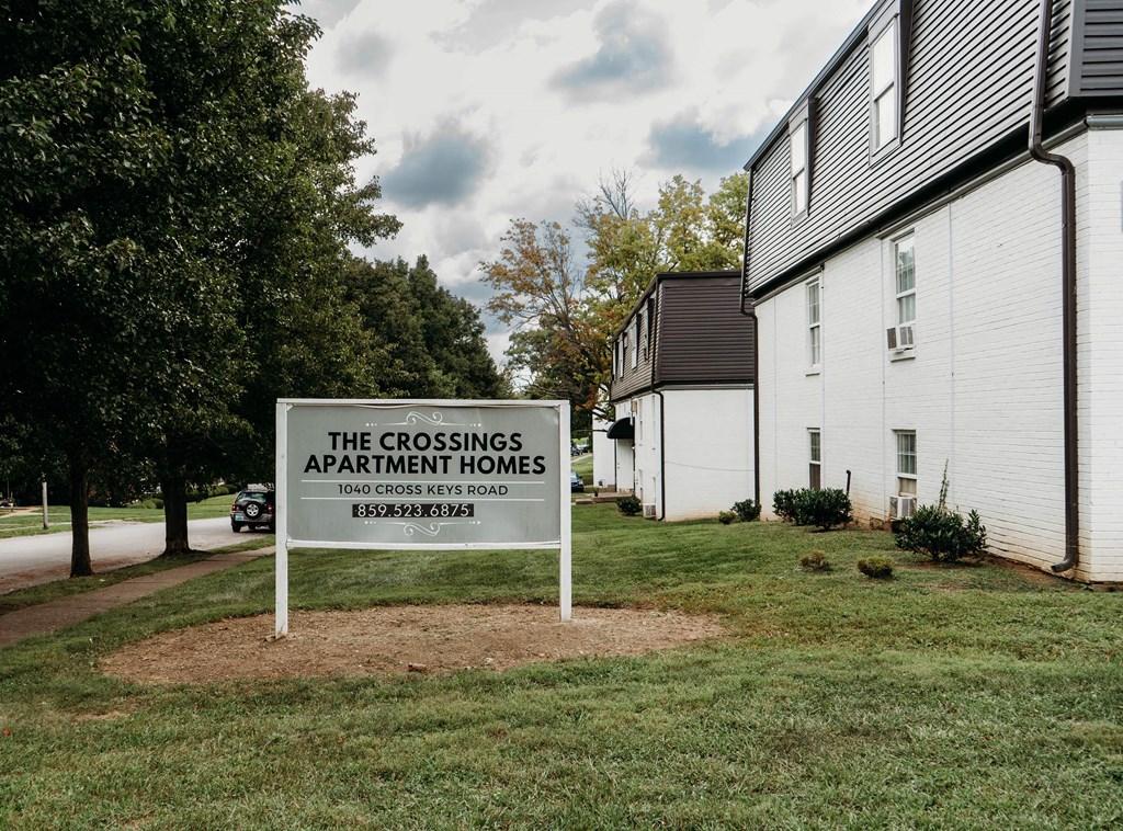 a sign for the crossings apartment homes in front of a house