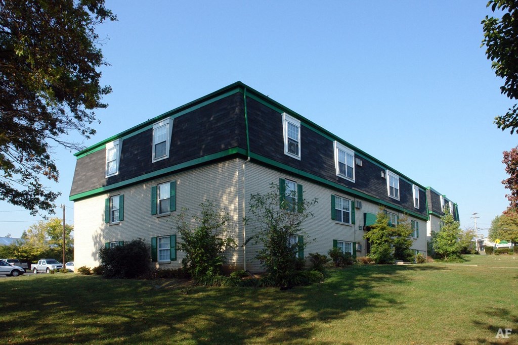 a large white house with a green roof on a lawn
