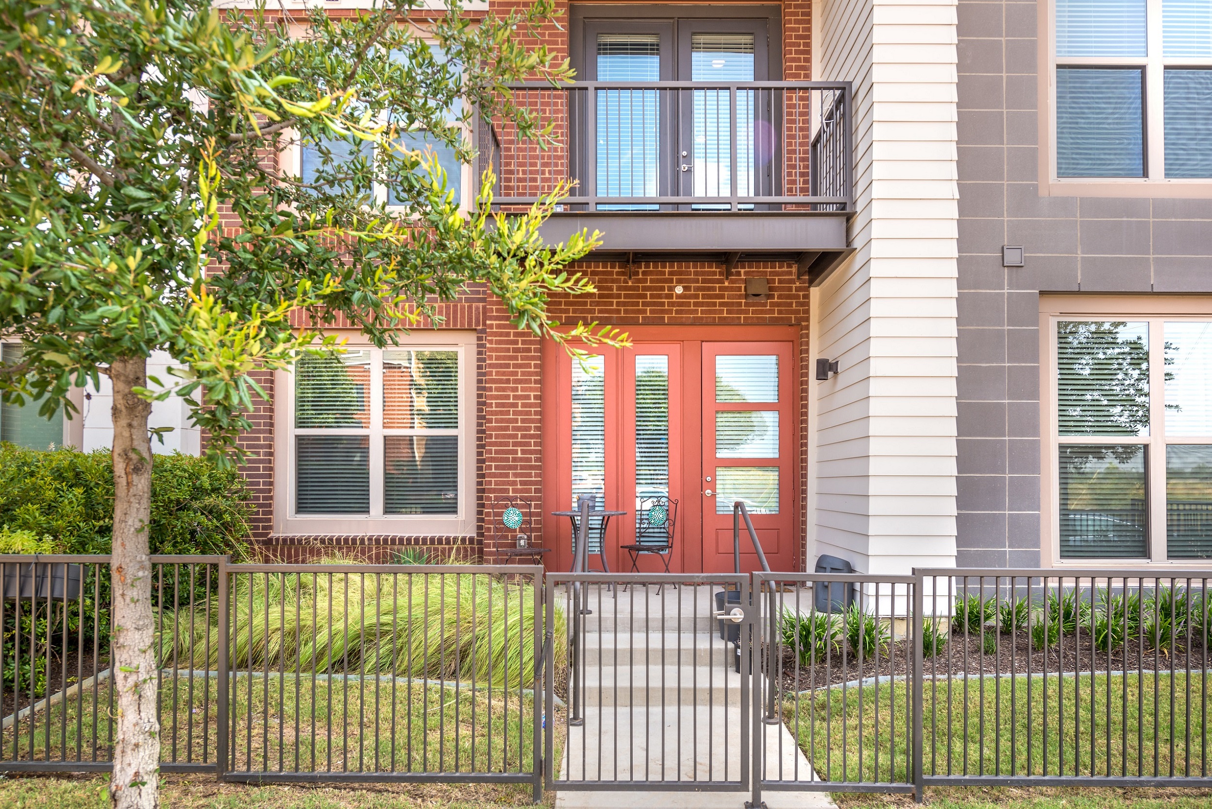 an apartment building with red doors and a balcony