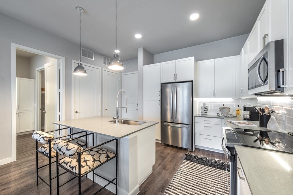 a kitchen with white cabinets and stainless steel appliances