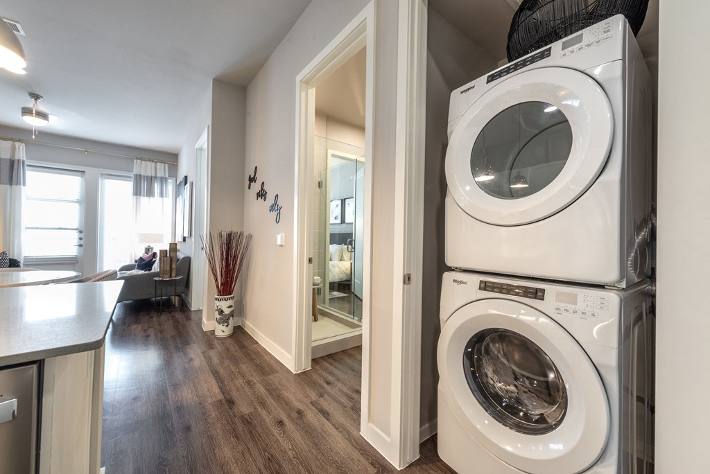 a front loading washer and dryer in a living room with a laundry room