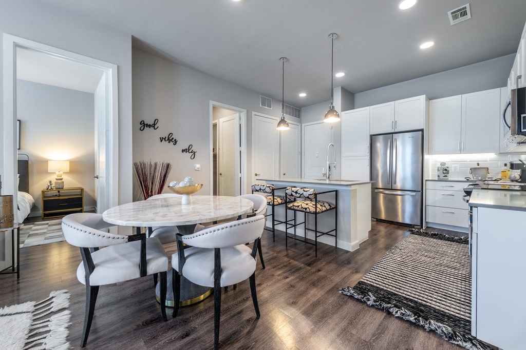 an open kitchen and dining room with a white table and chairs
