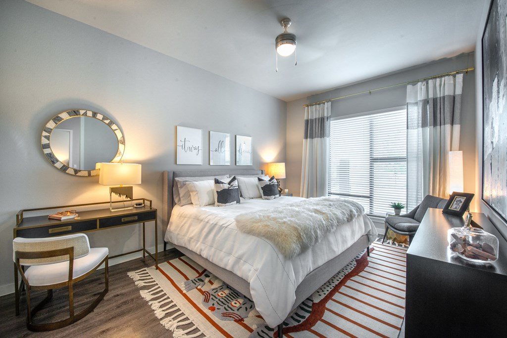 a bedroom with a bed and a desk and a mirror