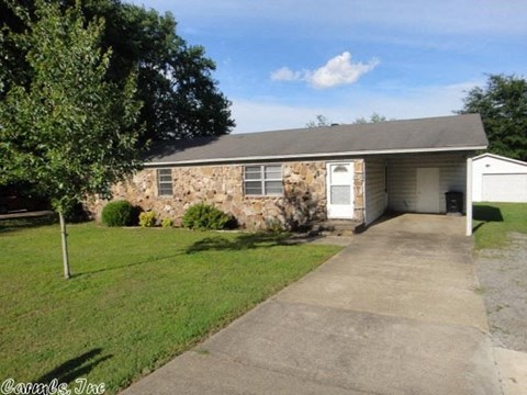 a small brick house with a sidewalk in front