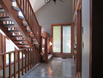 the entryway of a house with a staircase and a door