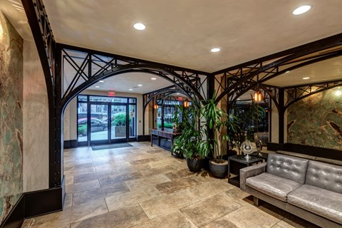 the lobby of a building with a couch and potted plants